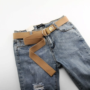 Détail de la ceinture en toile kaki avec imprimé marguerite et boucles en double D