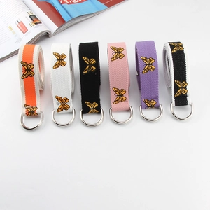 Detail of colorful canvas belts with butterfly embroidery and silver D-ring buckles