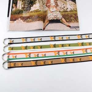 Detailed view of woven canvas belts with butterfly and daisy prints and D-ring buckles