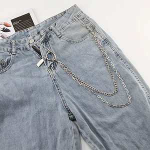 Detail of silver double-layered hip-hop metal trouser chain with pin hooks on blue denim jeans