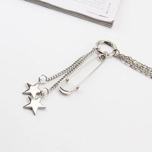 Detail of silver double-layered metal trousers chain with star pendants and safety pin
