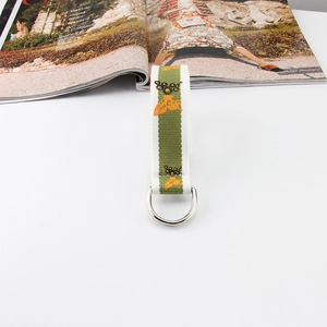 Detail of green and white striped canvas belt with butterfly embroidery and D-ring buckle