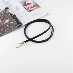 Détail de la fine ceinture en cuir noir pour femme avec boucle crochet en métal doré
