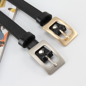 Detail of slim black leather belts with matte gold and silver square pin buckles
