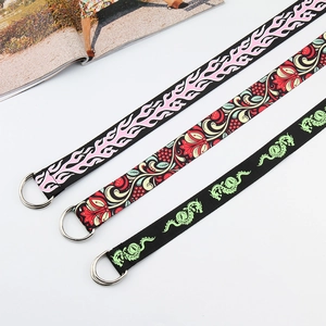 Detailed view of canvas belts featuring flame, floral, and dragon prints with D-ring buckles