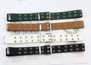 Detail view of double-prong canvas belts with star eyelets in four different stylish colors
