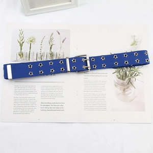 Detail of navy canvas belt featuring double rows of star-shaped metal eyelets and silver buckle