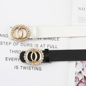 Ceintures fines noires et blanches avec boucle double cercle en strass sur magazine mode