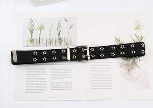 Detail of black canvas belt featuring double-row star eyelets and silver buckle