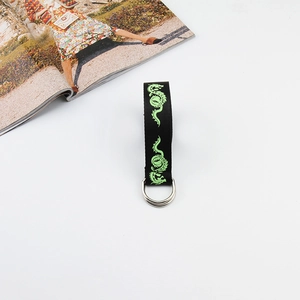 Detail of black canvas strap featuring green dragon print and dual silver metal rings
