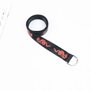 Close-up of black canvas belt featuring red dragon prints and silver double D-ring buckle