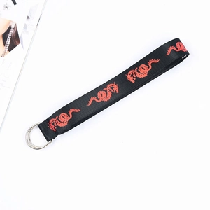 Detail of black canvas belt featuring red double dragon prints and silver D-rings