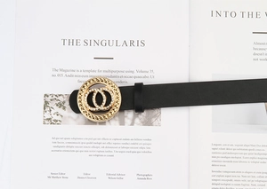 Détail d'une ceinture en cuir noir avec boucle dorée à doubles cercles et strass brillants