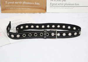 Close-up of black canvas belt with double silver metal grommets and square buckle detail