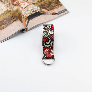 Detail view of red and green paisley printed canvas strap with silver metal D-ring