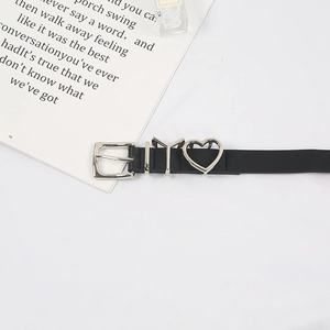 Détail d'une ceinture fine en cuir noir avec breloque cœur et curseur en métal lettre Y