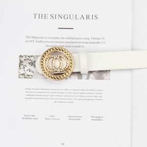 Détail de ceinture en cuir blanc avec boucle double anneau dorée et strass sur un magazine