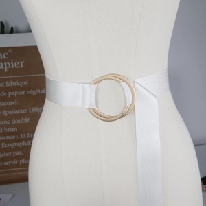 Close-up of a white canvas belt with minimalist double gold ring metal buckles