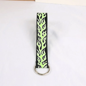 Detailed macro of the black canvas strap featuring green flame print and silver D-ring buckle