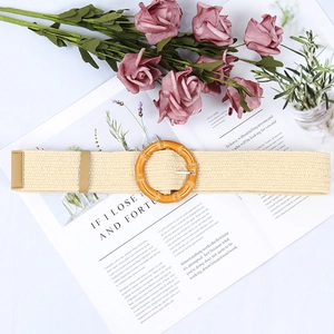 Bohemian beige woven waist belt with a round buckle styled over a magazine