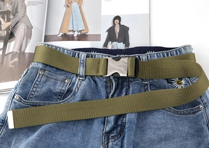 Armeegrüner taktischer Nylon-Gürtel mit silberner Metallschnalle auf blauer Jeanshose