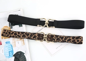 Detail of leopard print and black elastic waist belts with gold interlocking buckles