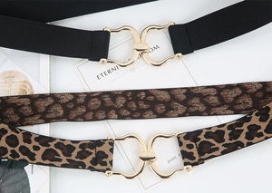 Detail of black and leopard print elastic belts with gold horseshoe alloy buckles