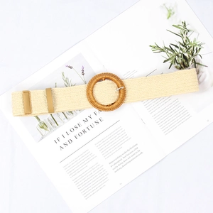 Detail of bohemian woven elastic belt with a round straw buckle on a lifestyle background