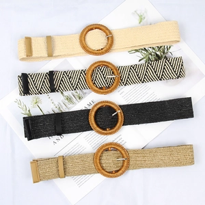Detail of four woven belts with round wooden buckles in beige, black, and khaki tones