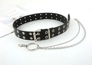 Dettaglio cintura punk nera con doppi occhielli e catene metalliche rimovibili