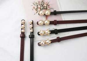 Detail of elegant pearl buckle on thin leather belts for suits and dresses