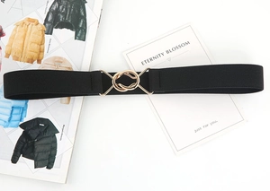 Detail of black elastic belt featuring polished gold interlocking circular buckles on top