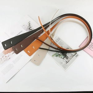 Detail of four colorful thin leather belts with litchi texture on magazine background