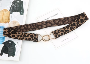 Detailed close-up of leopard print elastic belt with gold double-ring interlocking buckle
