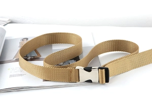 Detailansicht des khakifarbenen Nylon-Gürtels mit Metallschnalle auf einer Modezeitschrift