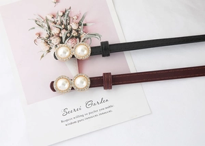 Detail of slim waist belts with pearl rhinestone buckles in black and burgundy leather