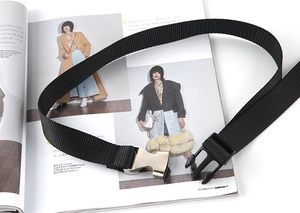 Detail eines schwarzen taktischen Nylon-Gürtels mit silberner Metallschnalle auf weißem Magazin