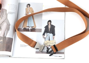 Brauner Nylon-Taktikgürtel mit Metallschnalle auf einem Modemagazin präsentiert