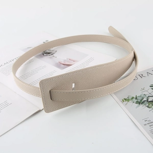 Detail of beige lychee pattern leather belt with a large rectangular leather-wrapped buckle