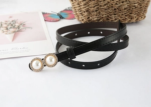 Detail of thin black PU leather belt featuring rhinestone-encrusted double pearl buckle