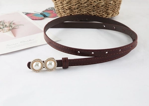 Detail view of dark brown leather belt featuring pearl buckle with rhinestone accents
