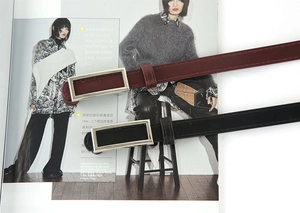 Close-up of black and burgundy slim leather belts with silver rectangular metal buckles