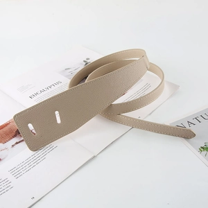 Detail of beige lychee pattern faux leather waist belt on a magazine background