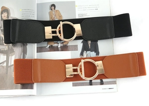 Detail of black and brown wide elastic waist belts with shiny gold circular metal buckles