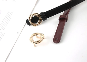 Close-up of slim waist belts with golden wavy buckle in black and burgundy leather