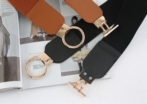 Detail of black and tan elastic wide belts with golden rings and lychee texture