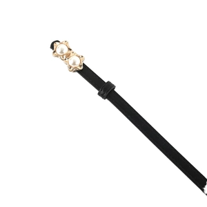 Minimalist black faux leather belt featuring a gold star buckle with pearl accents