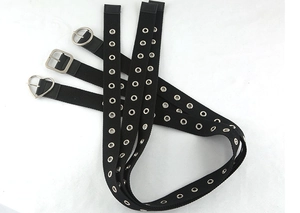 Dettaglio di cinture punk in tela nera con occhielli metallici e fibbie geometriche