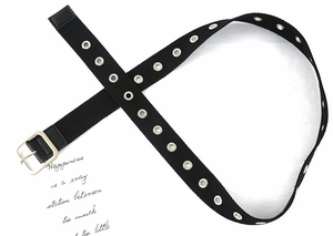 Dettaglio della cintura punk nera con occhielli in metallo argento e fibbia quadrata