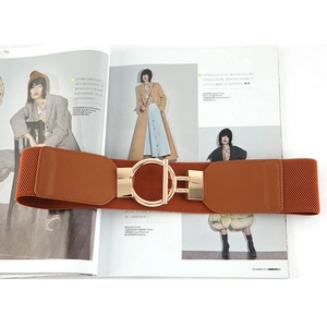 Brown elastic waist belt with gold round buckle on fashion magazine for coat styling